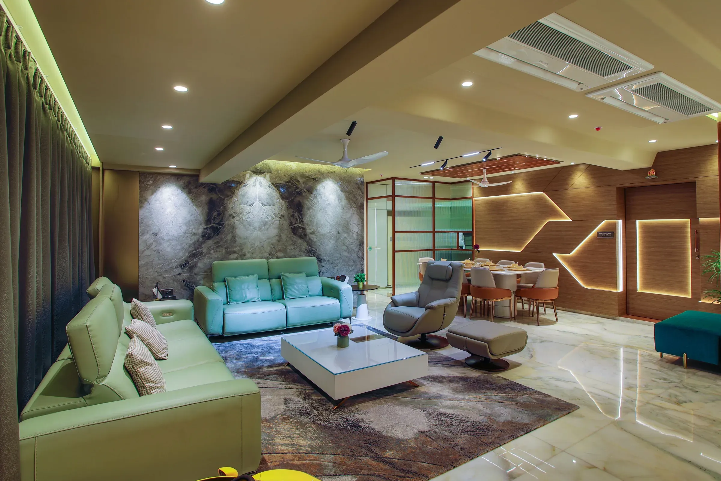 Indian living room with mint leather sofas, a stone feature wall, recliner, LED-patterned wall and dining area