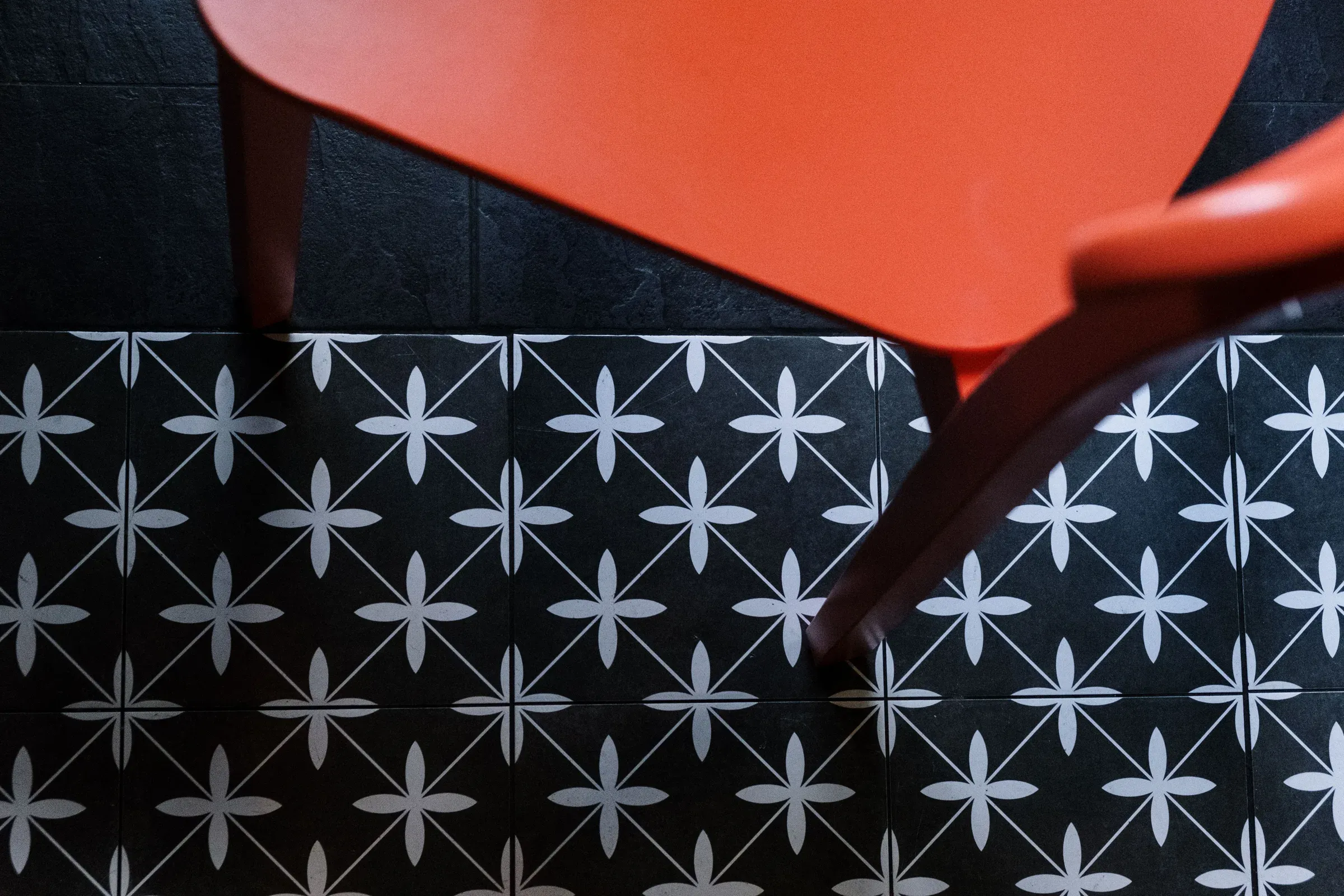 Black-and-white star-pattern floor tiles seen from above with a red chair