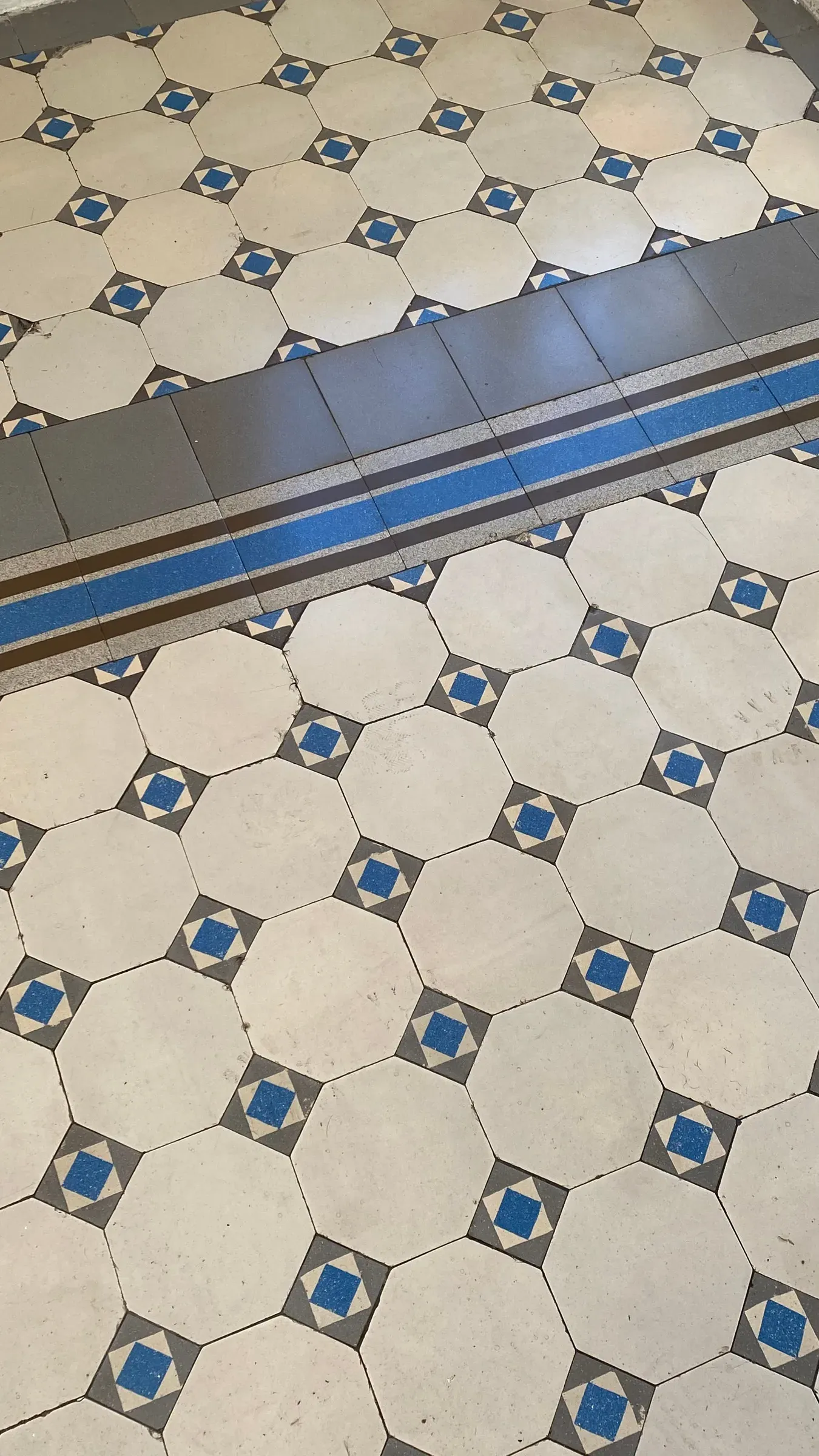 Cream octagon floor tiles with blue dot inserts and a blue-striped border