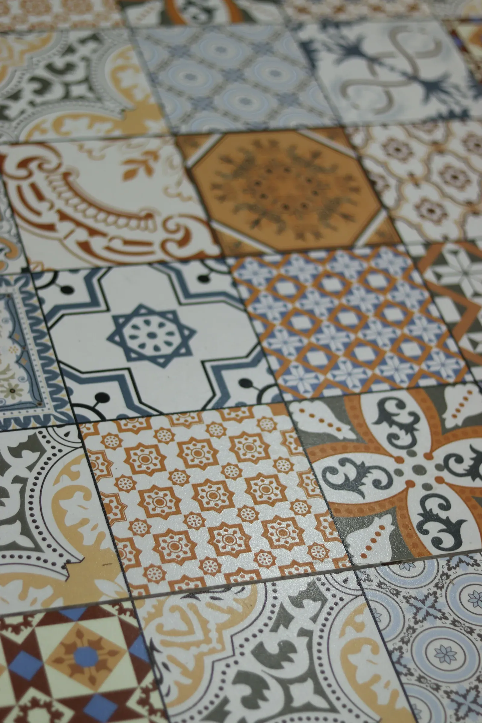 Patchwork of Spanish-style patterned tiles in orange, blue and grey