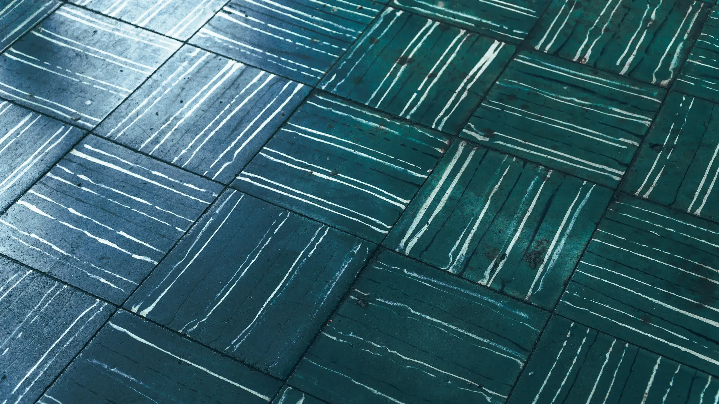 Teal glazed tiles laid in a basket-weave parquet pattern