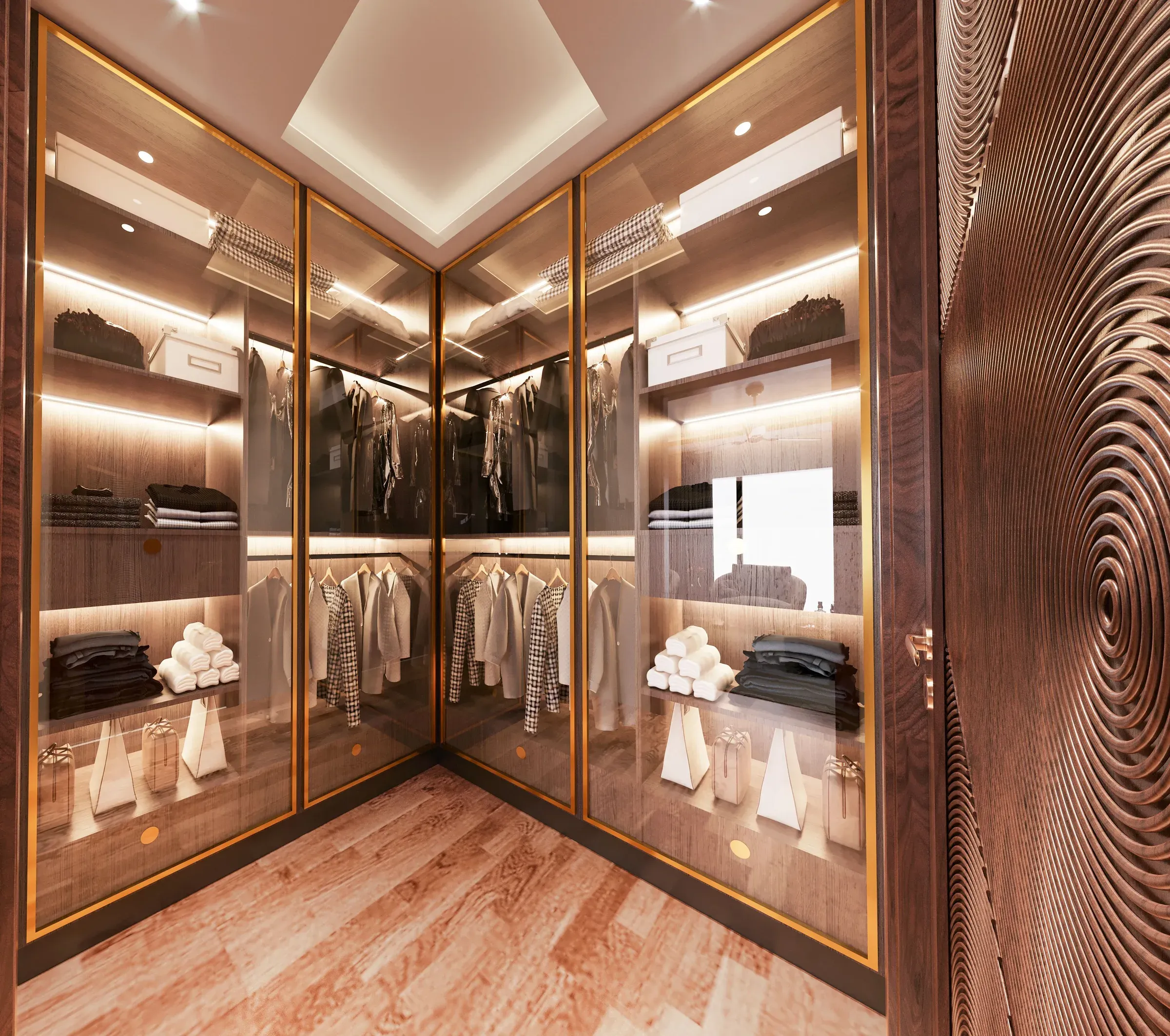 Luxury walk-in closet with gold-framed glass doors, lit shelves and a carved wooden wall